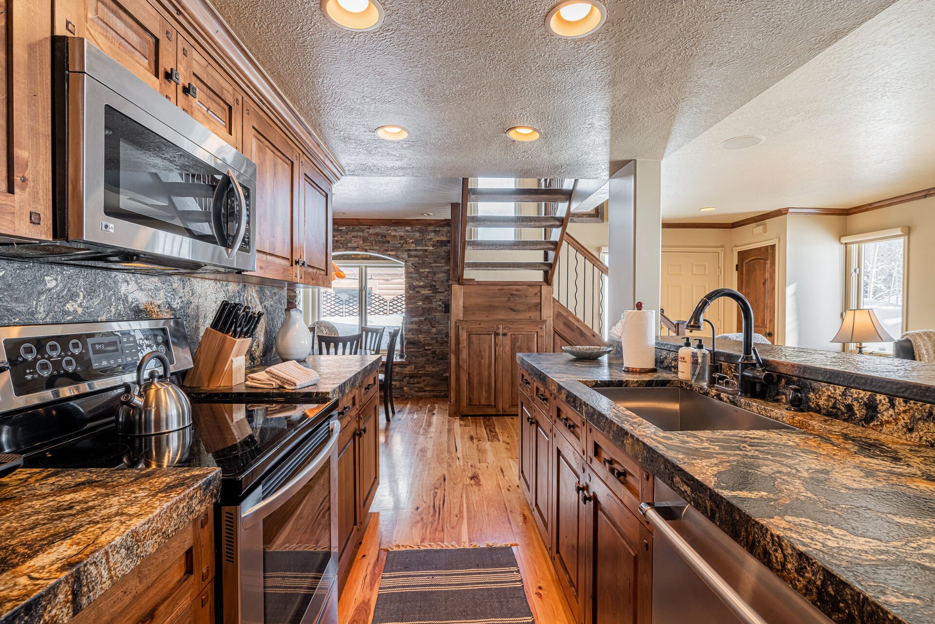 Fully Equipped Kitchen with gorgeous stone countertops, stainless steel appliances, and bar seating for 3