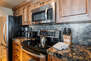 Fully Equipped Kitchen with gorgeous stone countertops, stainless steel appliances, and bar seating for 3