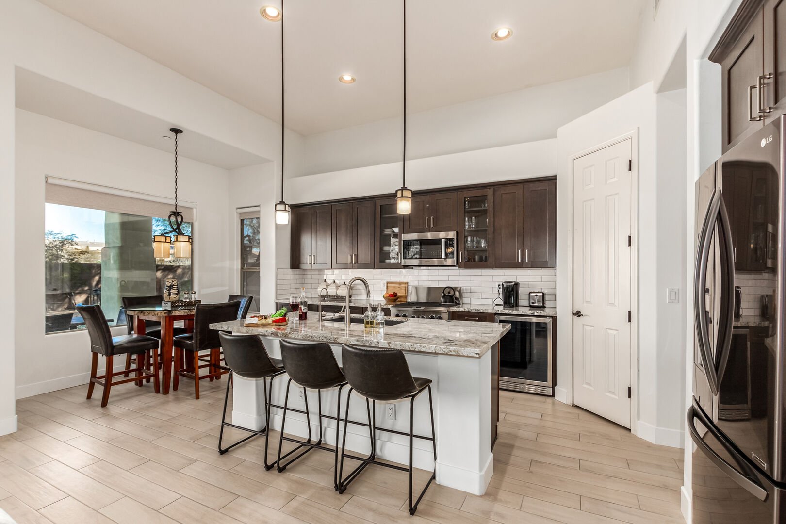 Fully Equipped Kitchen stocked with basic cooking essentials and stainless steel appliances overlooking informal dining area.