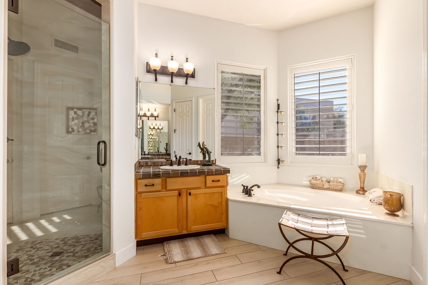 Primary Bathroom featuring two single vanities, bathtub and stand-in shower.