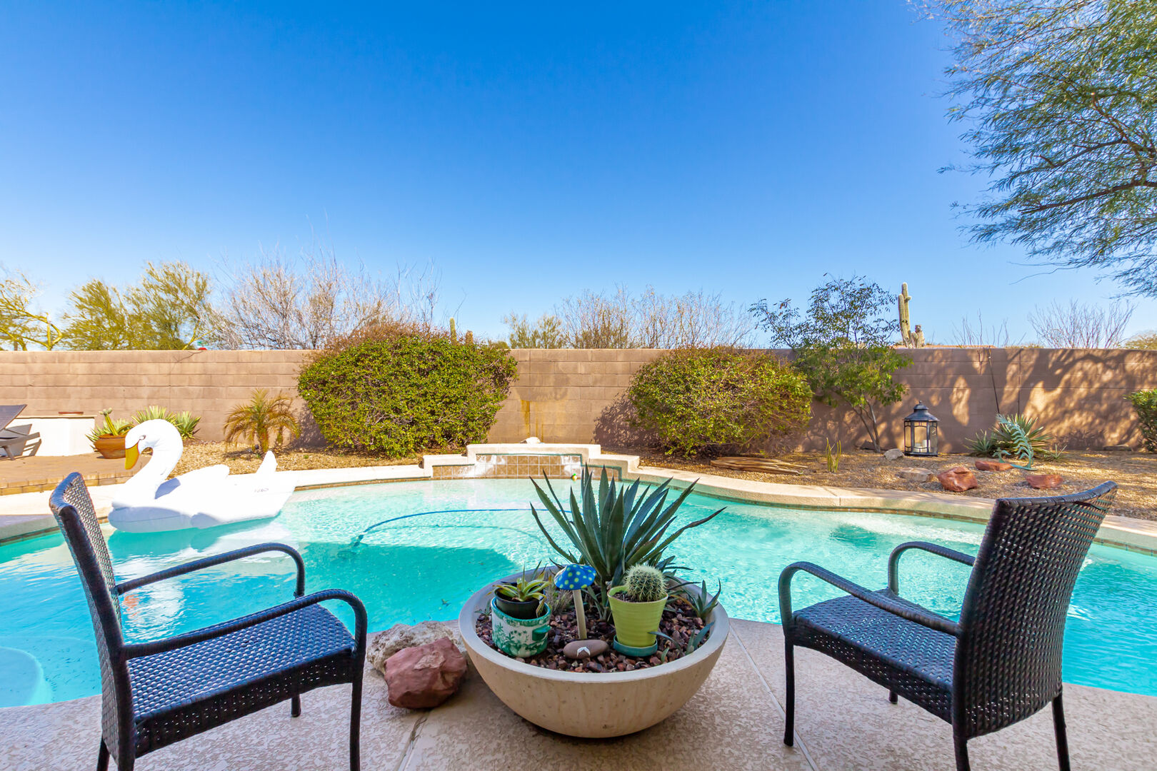 Private Backyard featuring Sparkling Blue Pool, Sun Loungers, Fire Pit, BBQ Grill, and Covered Patio with Space Heater and Lounging Areas.