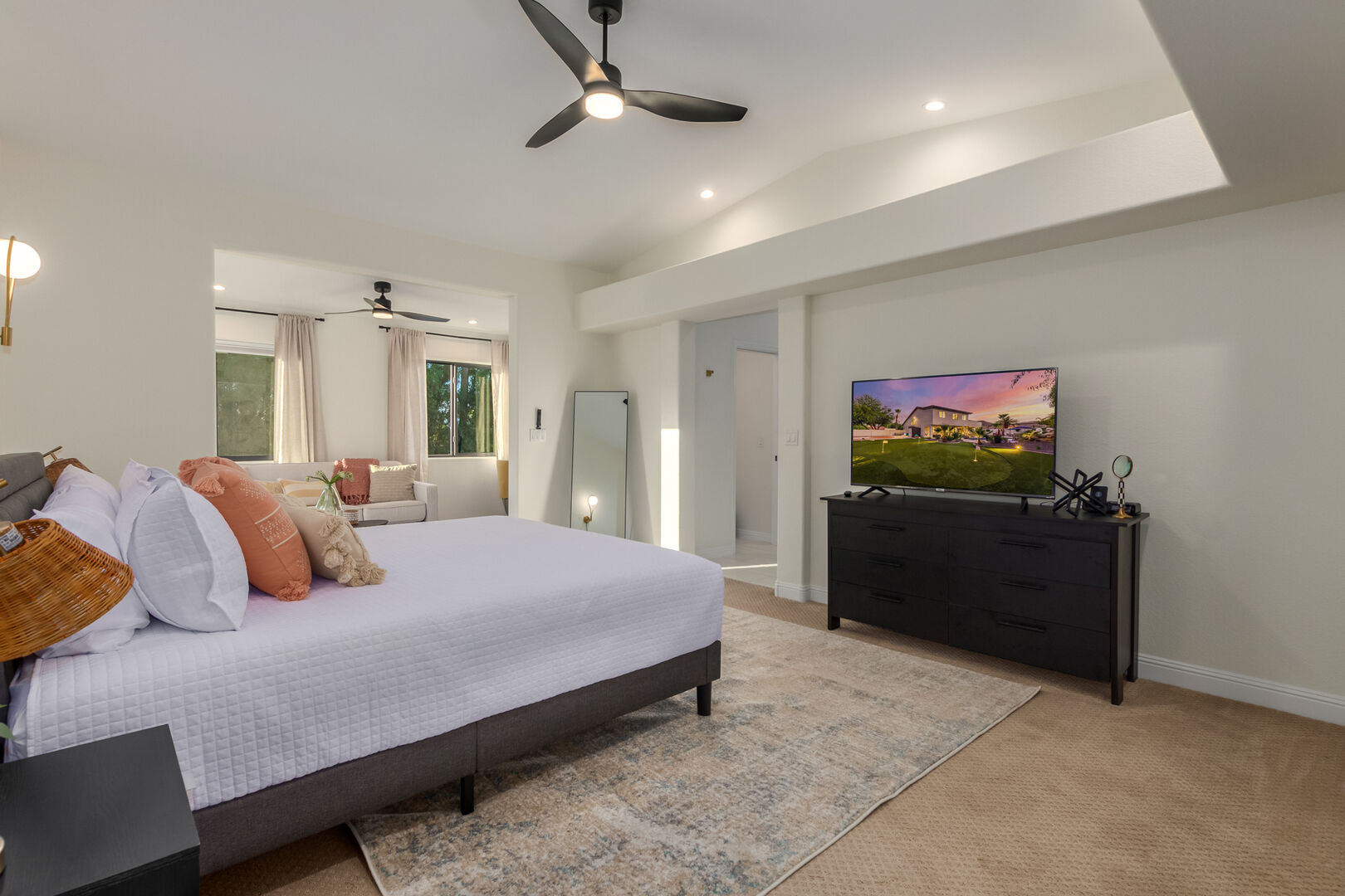 Master bedroom with television and seating area.