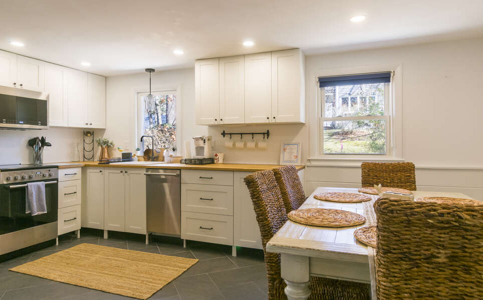 Updated white kitchen with butcherblock counters and stainless steel appliances.