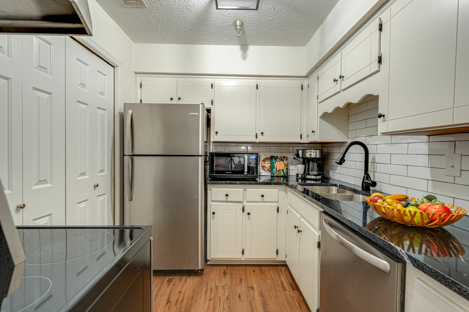 Full kitchen stocked with basic cooking essentials and stainless steel appliances.