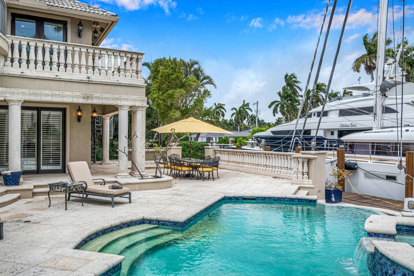 The heated swimming pool with loungers and waterfront views.