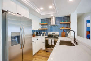 Fully equipped kitchen with new stainless steel appliances, quartz countertops and modern features