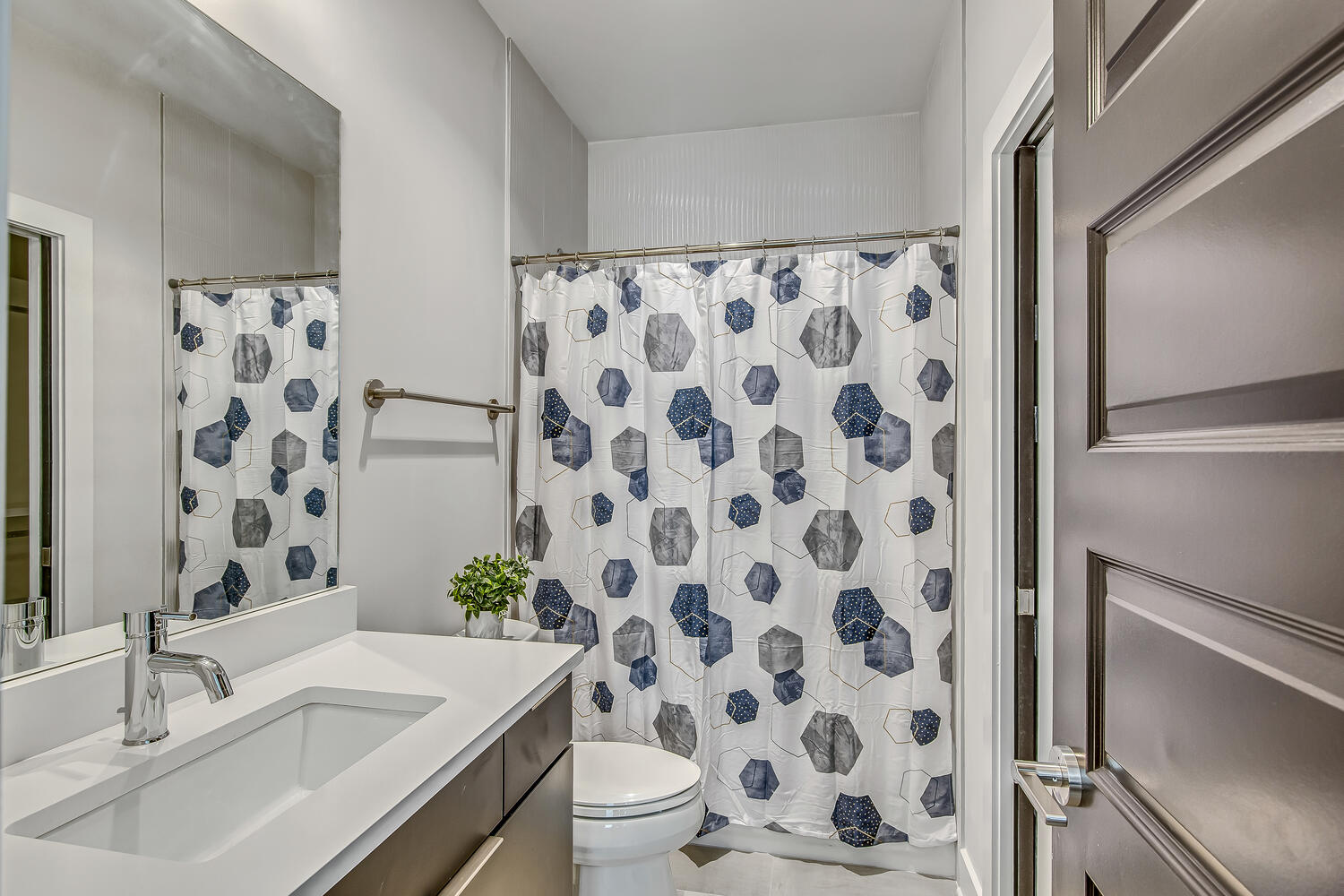 Unit 2: 4th Bathroom (1st floor) En-suite bathroom with shower/tub combo and large vanity.