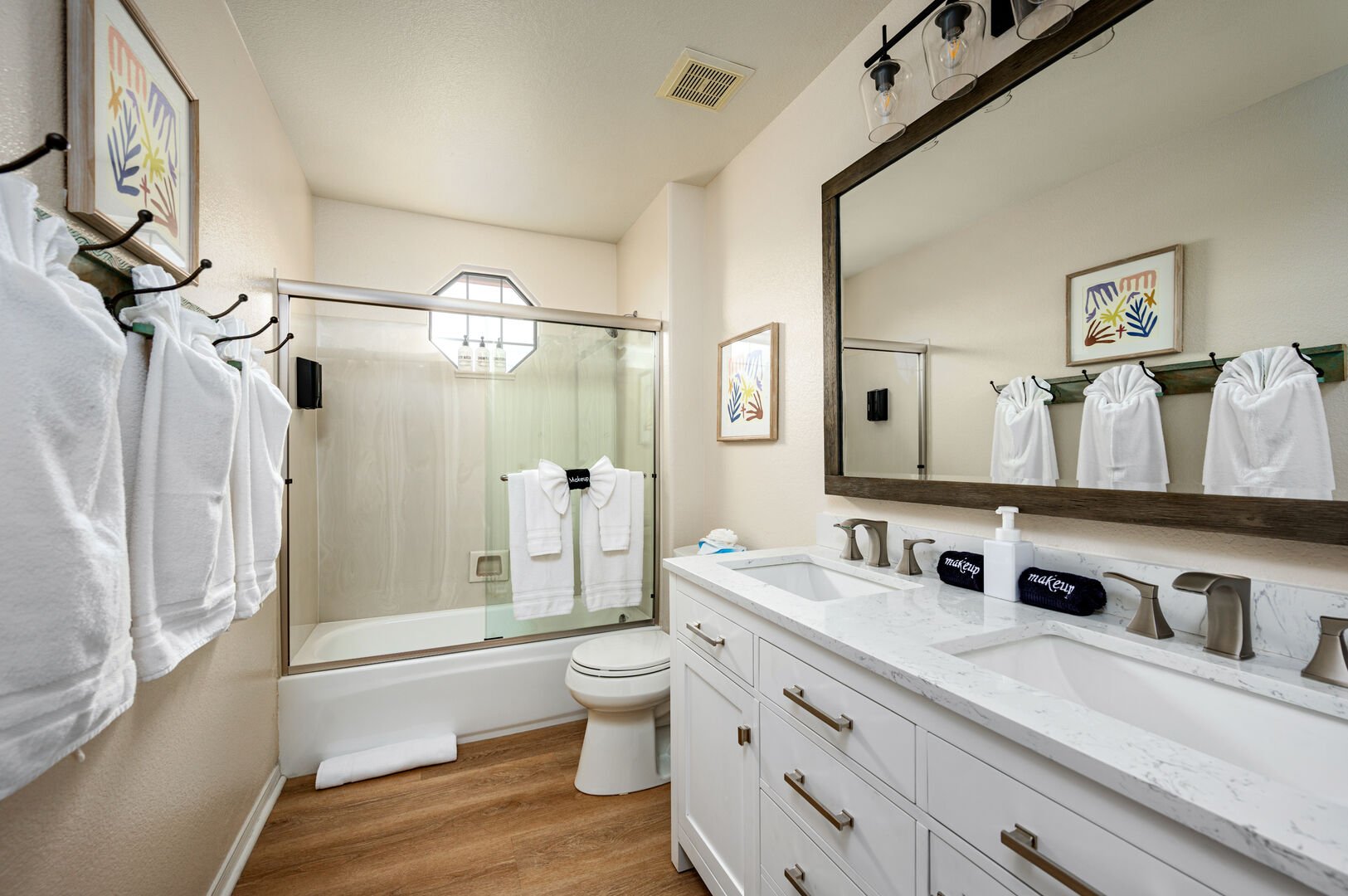 Hall bathroom with double sinks and combo shower tub.