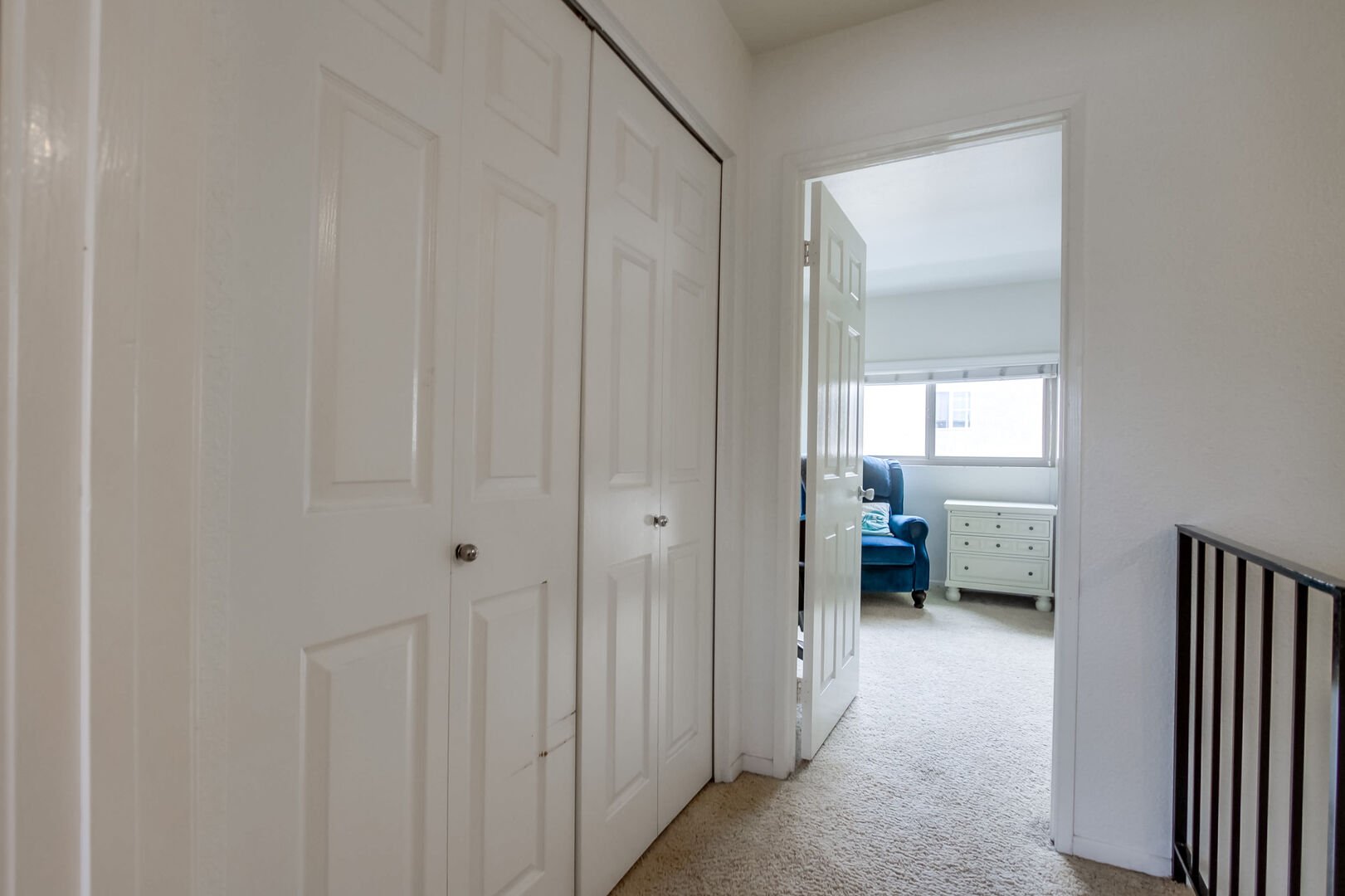 Upstairs hallway with washer and dryer closet in between dual master bedrooms