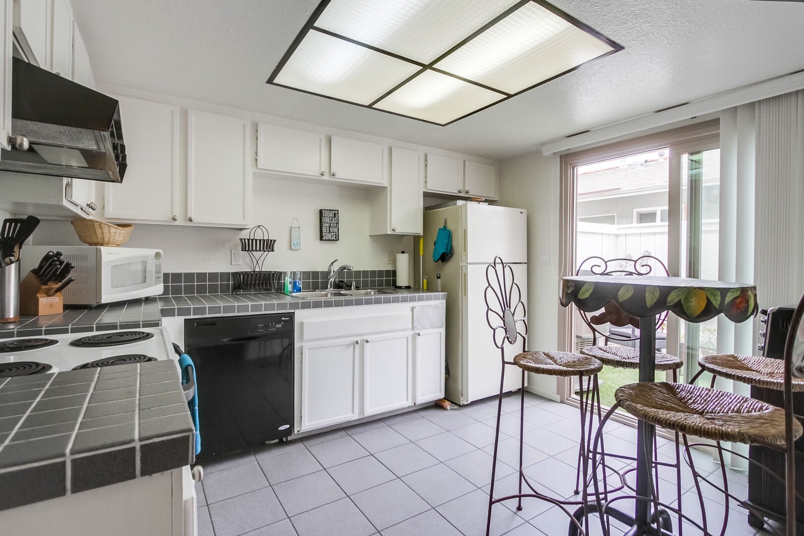 Fully equipped kitchen for meals at home with basic appliances including a dishwasher, stove and oven, refrigerator and freezer, standard coffee maker, blender, toaster and microwave