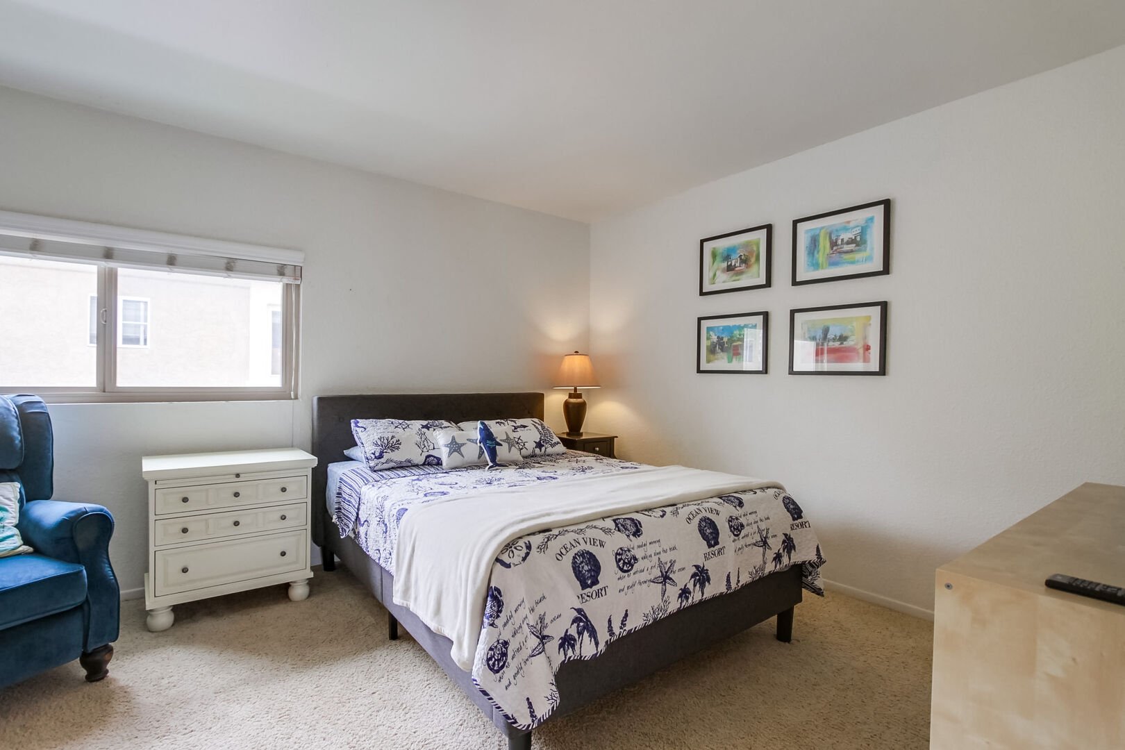 Upper level dual master bedroom with queen size bed, dresser storage, smart TV, walk-in closet and in-suite full bathroom