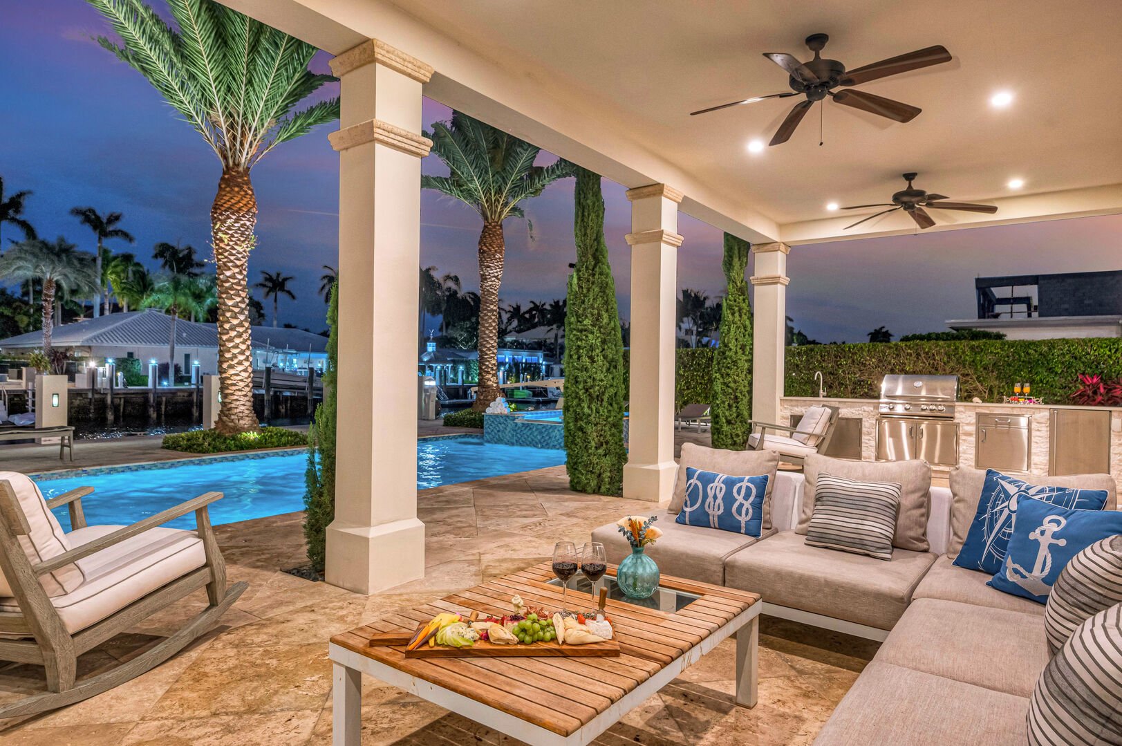Covered patio features a grill and a seating area with its TV.