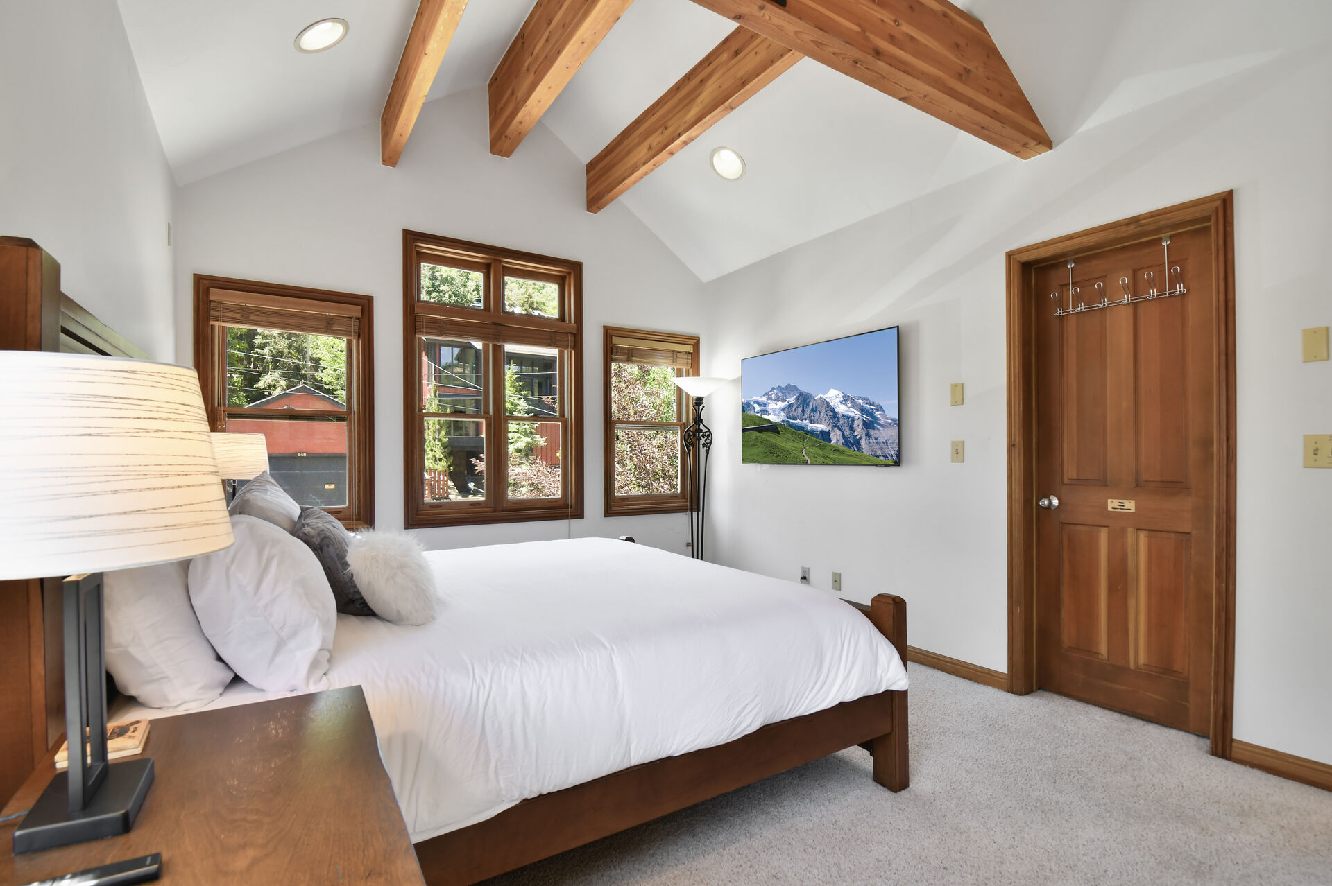 Master bedroom with custom wooden beams in vaulted ceiling room