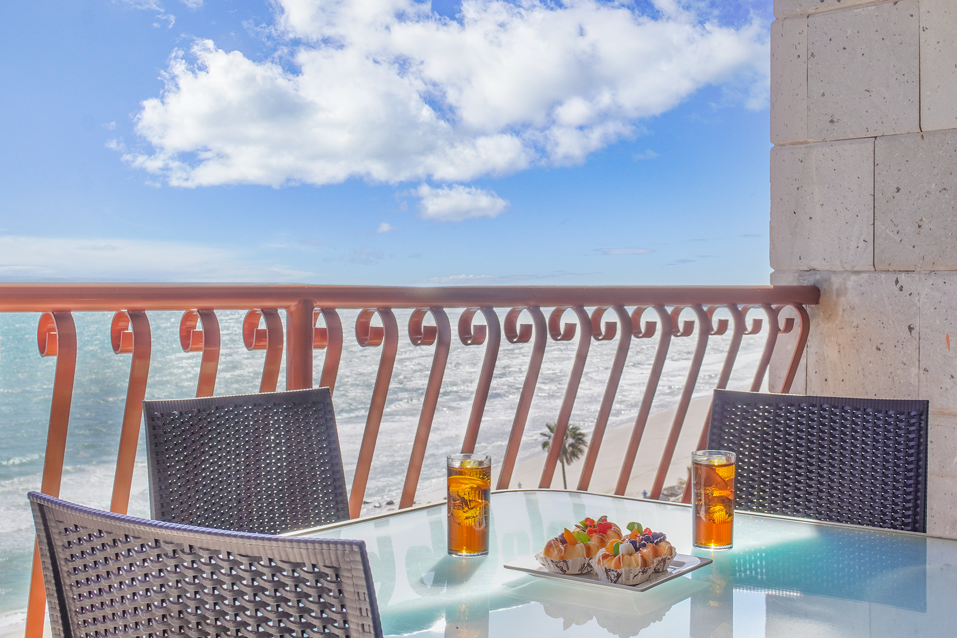 enjoy blue skies and waves below from the patio with its dining table for four