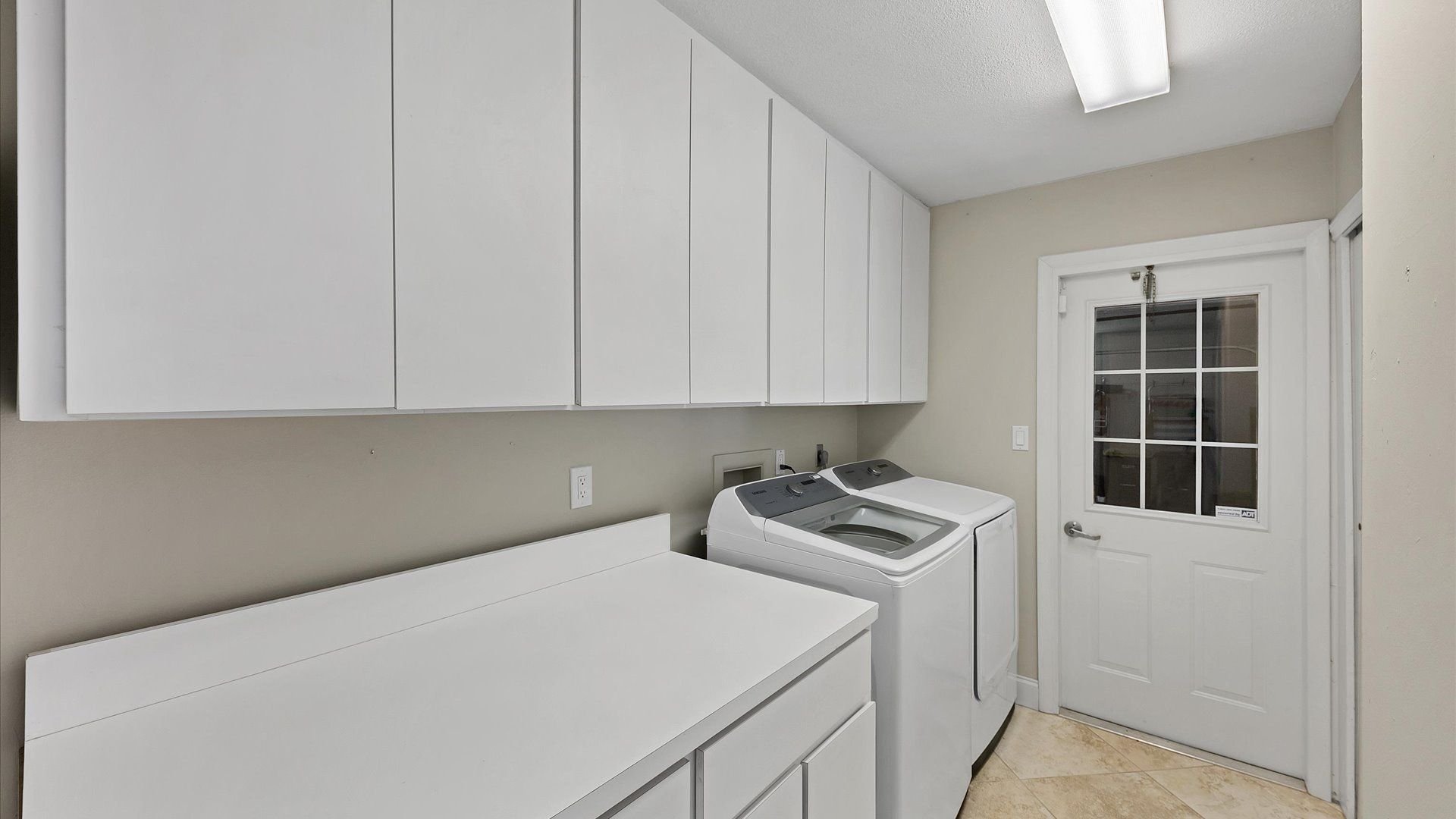 Washer and dryer in laundry room with garage access