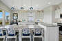 You'll love mealtime in this beautiful kitchen with pops of blue in the lighting and fabric with a playful ocean design.