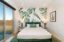 Channel your inner tropical creative from this bright bedroom and enjoy the green leaf accents.