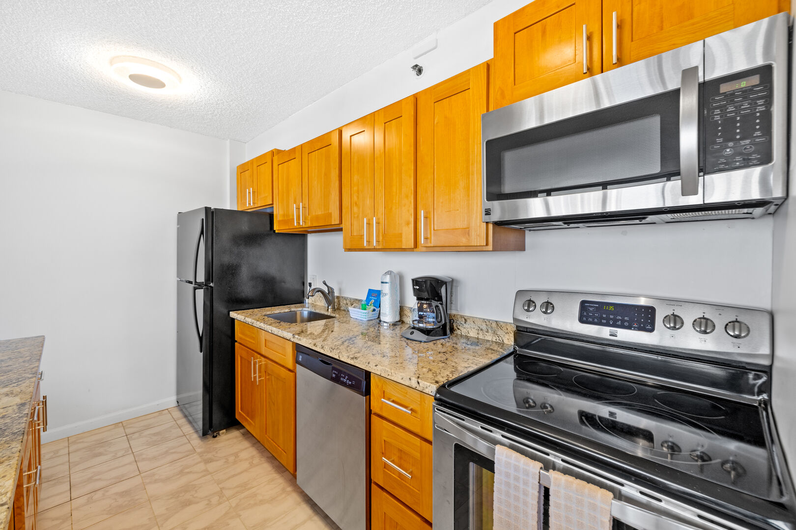Fully equipped kitchen includes refrigerator, dish washer, stove, oven, and microwave