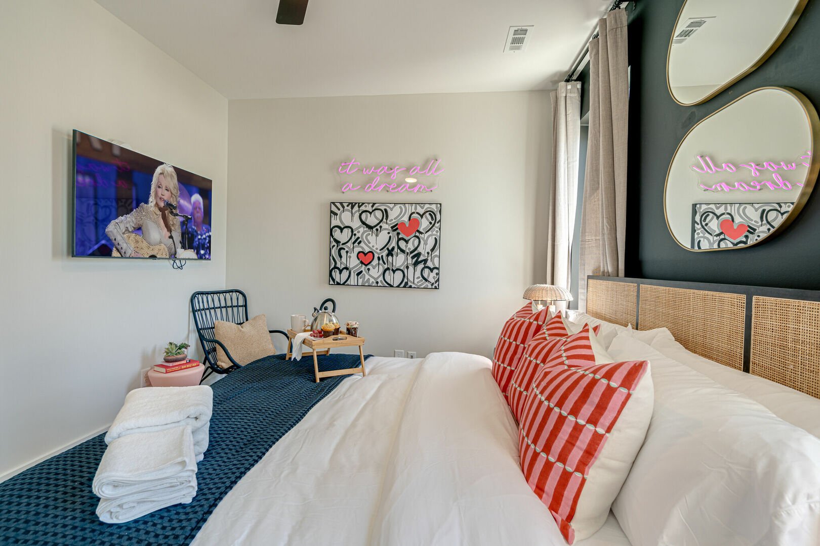 Primary bedroom with King bed, designer furnishings, smart TV, and en-suite bathroom.