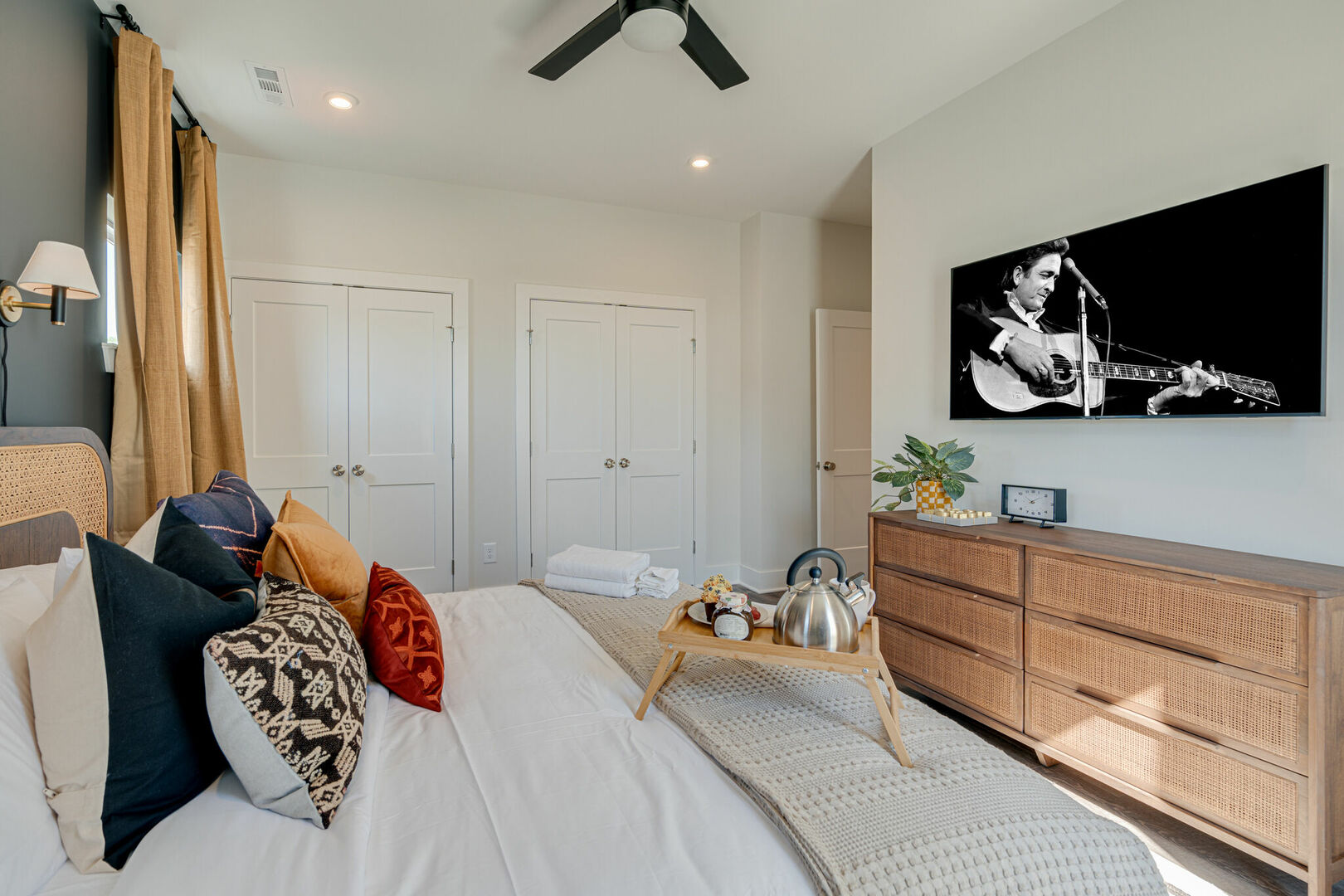 Primary bedroom with King bed, designer furnishings, smart TV, closet, and en-suite bathroom.
