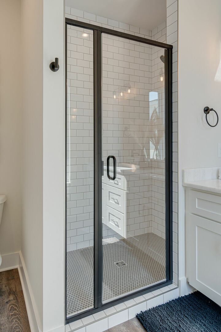 Primary bathroom with dual vanities and stand-in shower.
