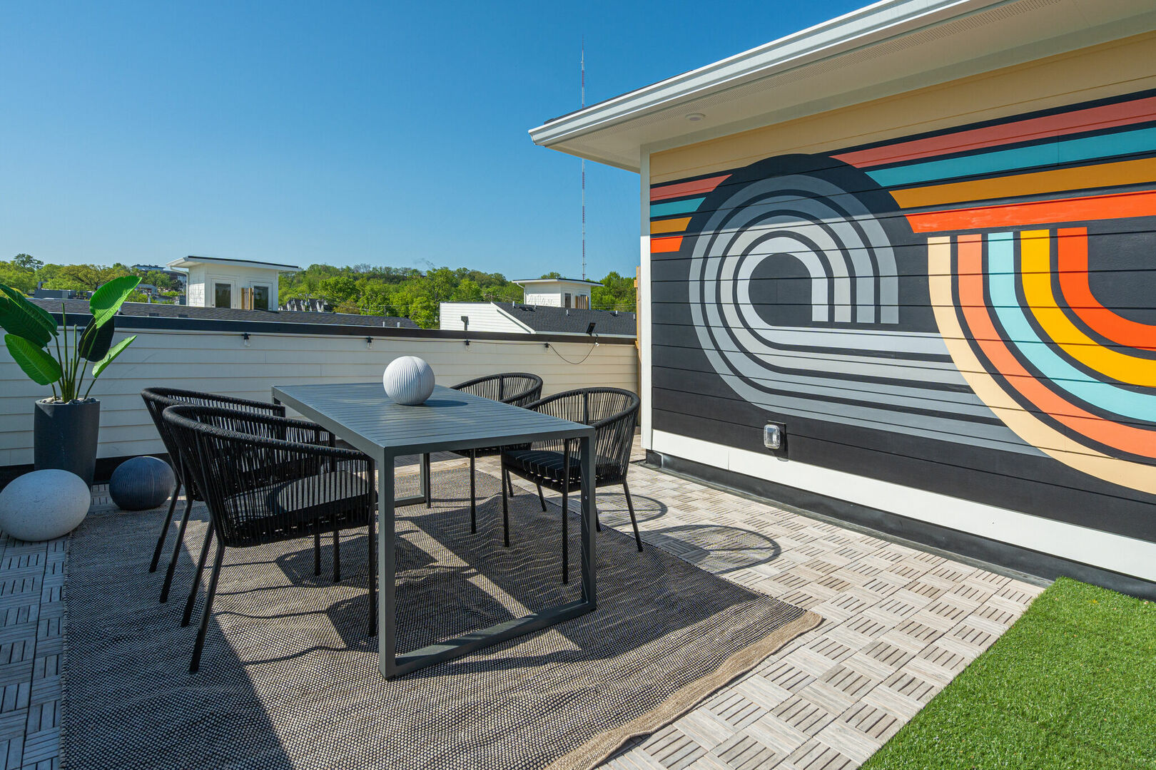 Private rooftop deck outdoor dining table (seats 4) and lounge area. Entire space is lined with bistro lights and includes a photo op mural!