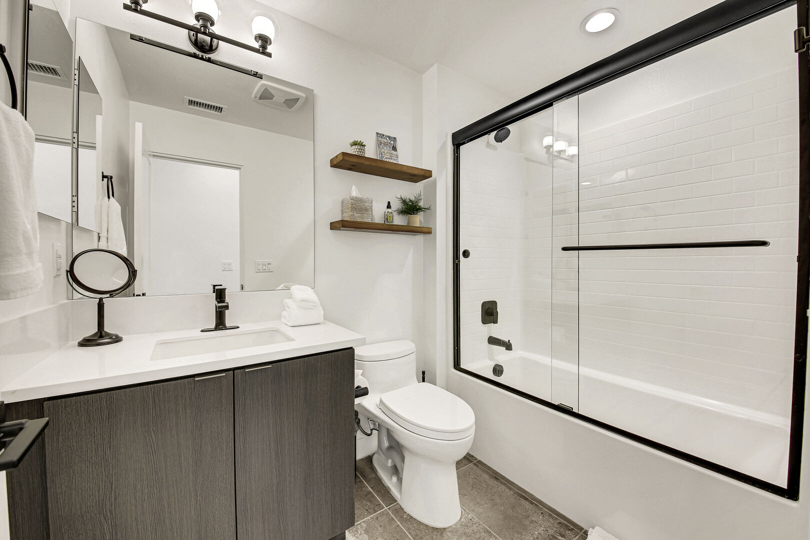 The hallway bathroom is located next to the laundry room and features a shower, bathtub combo and a vanity sink.