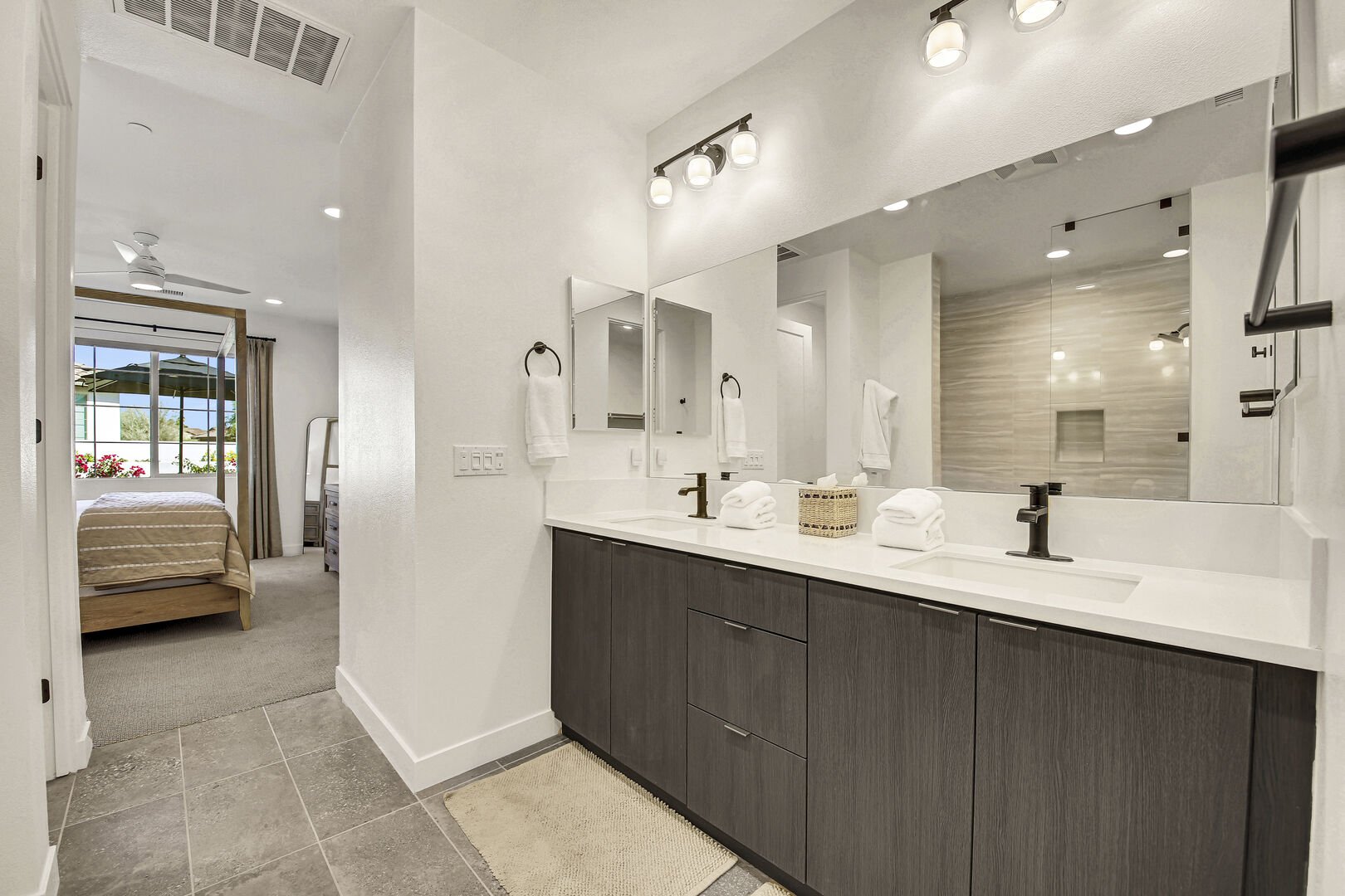 The private en suite bathroom features a large tile shower and double vanity sinks.