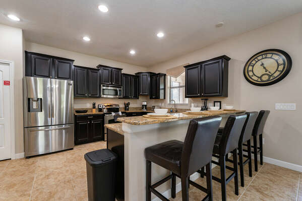 Kitchen showing cabinets and appliances along with breakfast bar seating 4