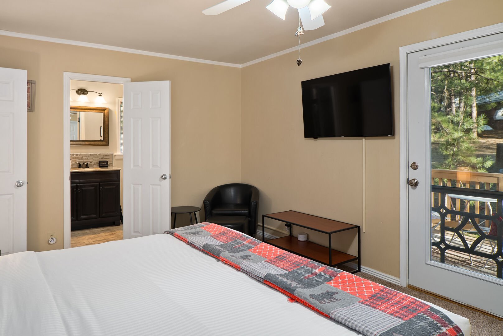 Bedroom 1 offers a flat screen TV, seating in the corner and an ensuite bathroom.