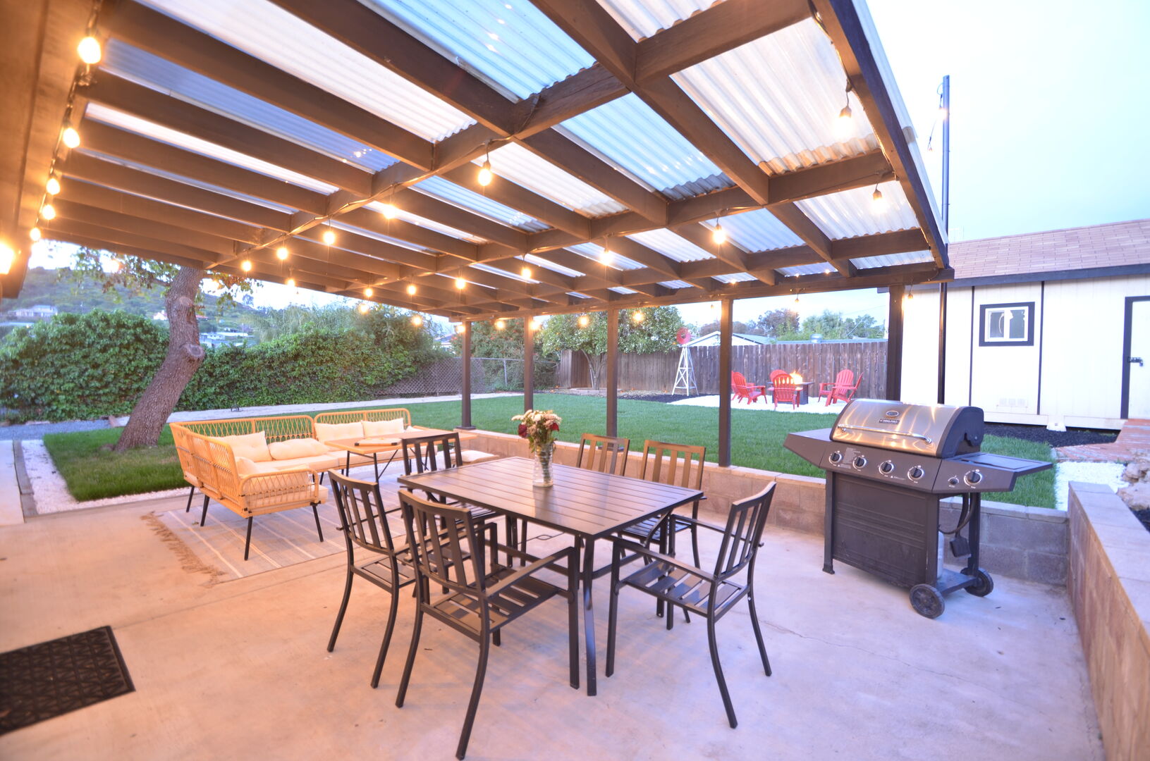 Covered patio with dining, lounge chairs and propane grill