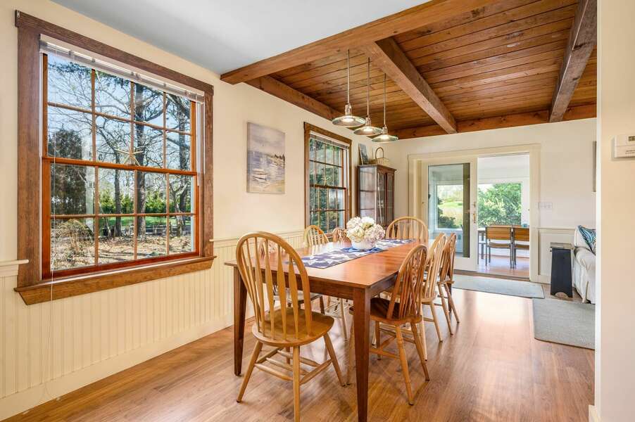 Dining table bathed in light from nearby window and screened porch in the distance - 18 Beach Road West Harwich - Cape Cod - Beach Plum Cottage - NEVR