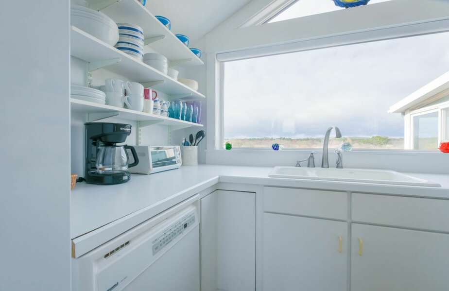 Bright white kitchen with a large window looking out into the marsh.