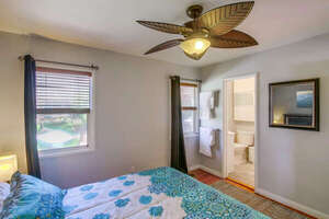 First bedroom with king bed, ceiling fan, and in-suite shared full bathroom shared (accessible from 2 doors)