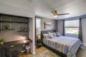 Second bedroom with king bed, ceiling fan, workplace desk, and window a/c unit!