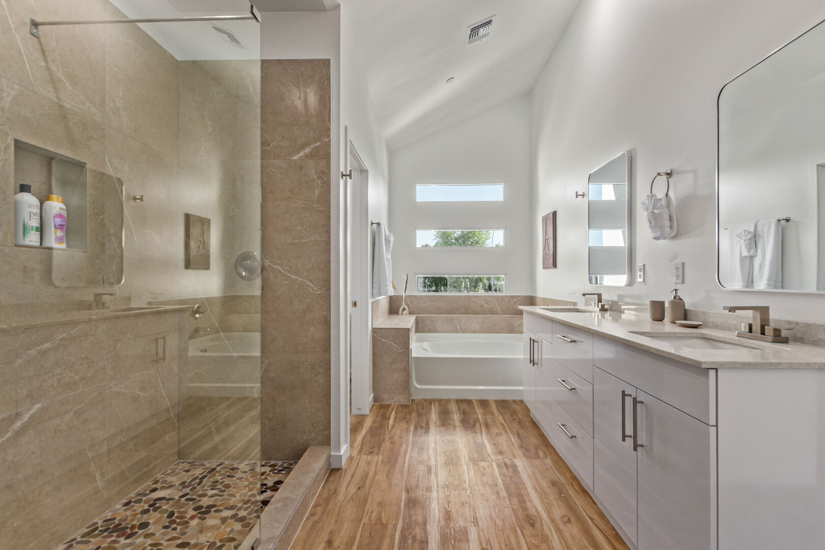 Primary bathroom with dual vanities, large tub, and large stand-in shower.