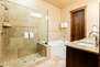 Upper level bunkroom en suite bathroom with large glass shower and tub