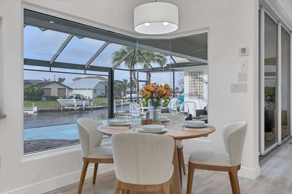 Small dining table overlooking pool & canal