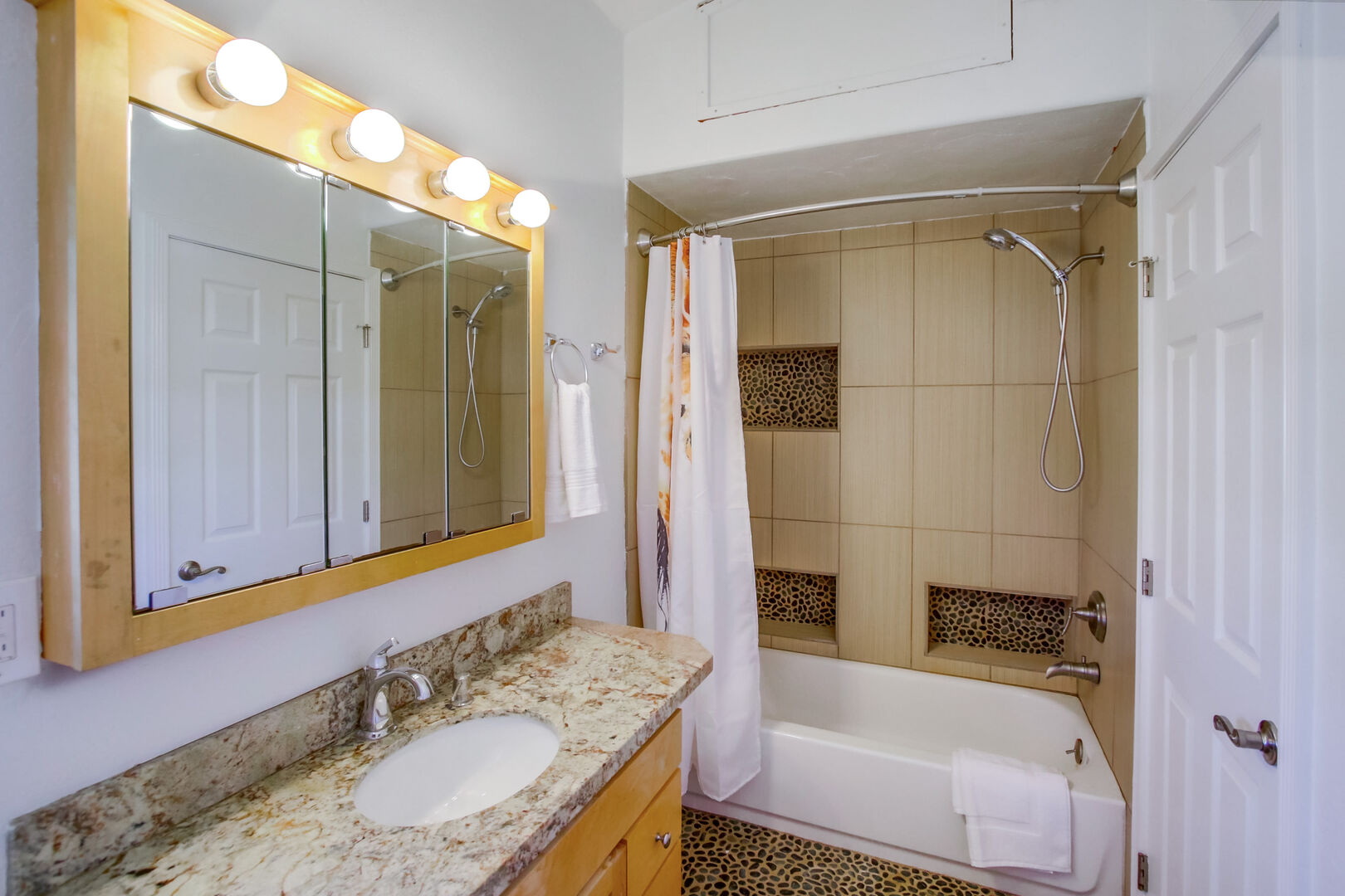 Bathroom with large vanity, storage and shower-tub combo
