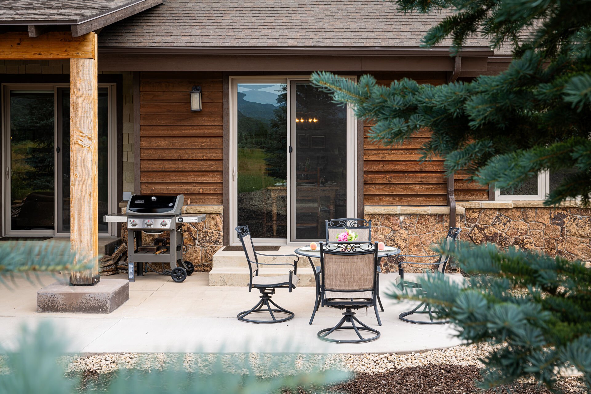 Private patio with outdoor dining table and propane grill