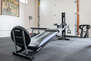 Fitness area with exercise equipment and infrared sauna located in garage.
