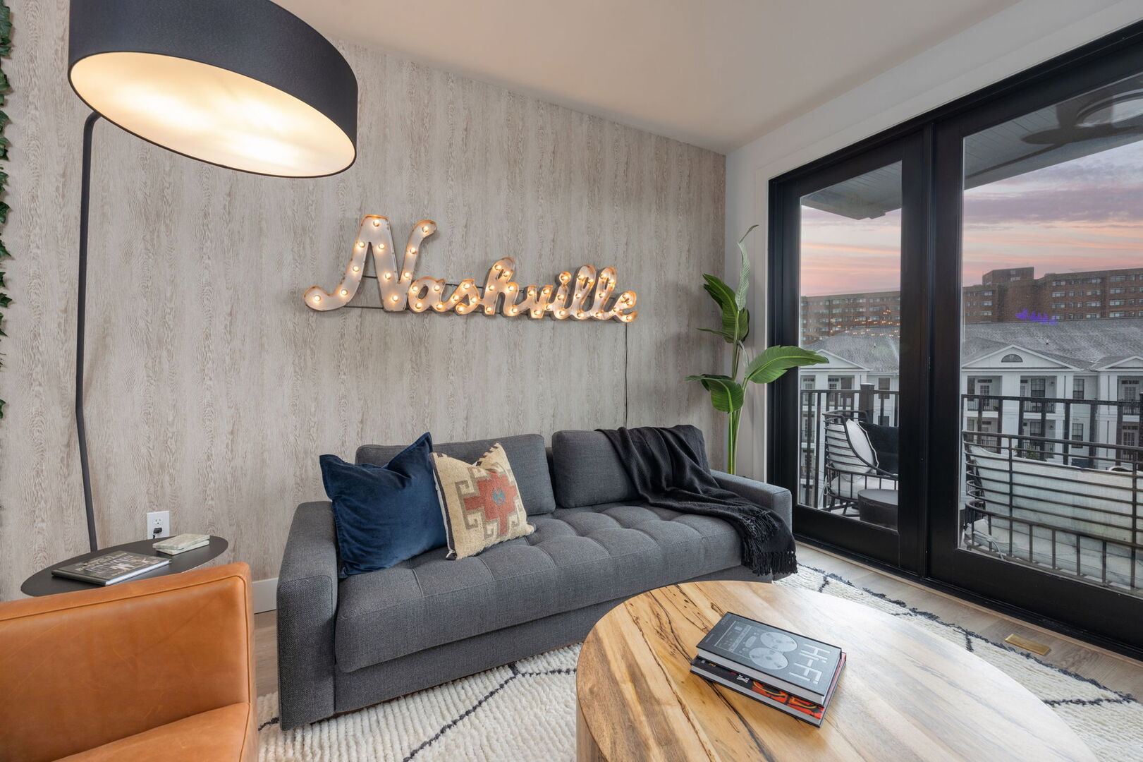 Warm and inviting living room featuring cozy designer furnishings, a Smart TV for entertainment, and a private balcony.