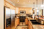 Fully equipped kitchen features stone countertops and stainless steel appliances