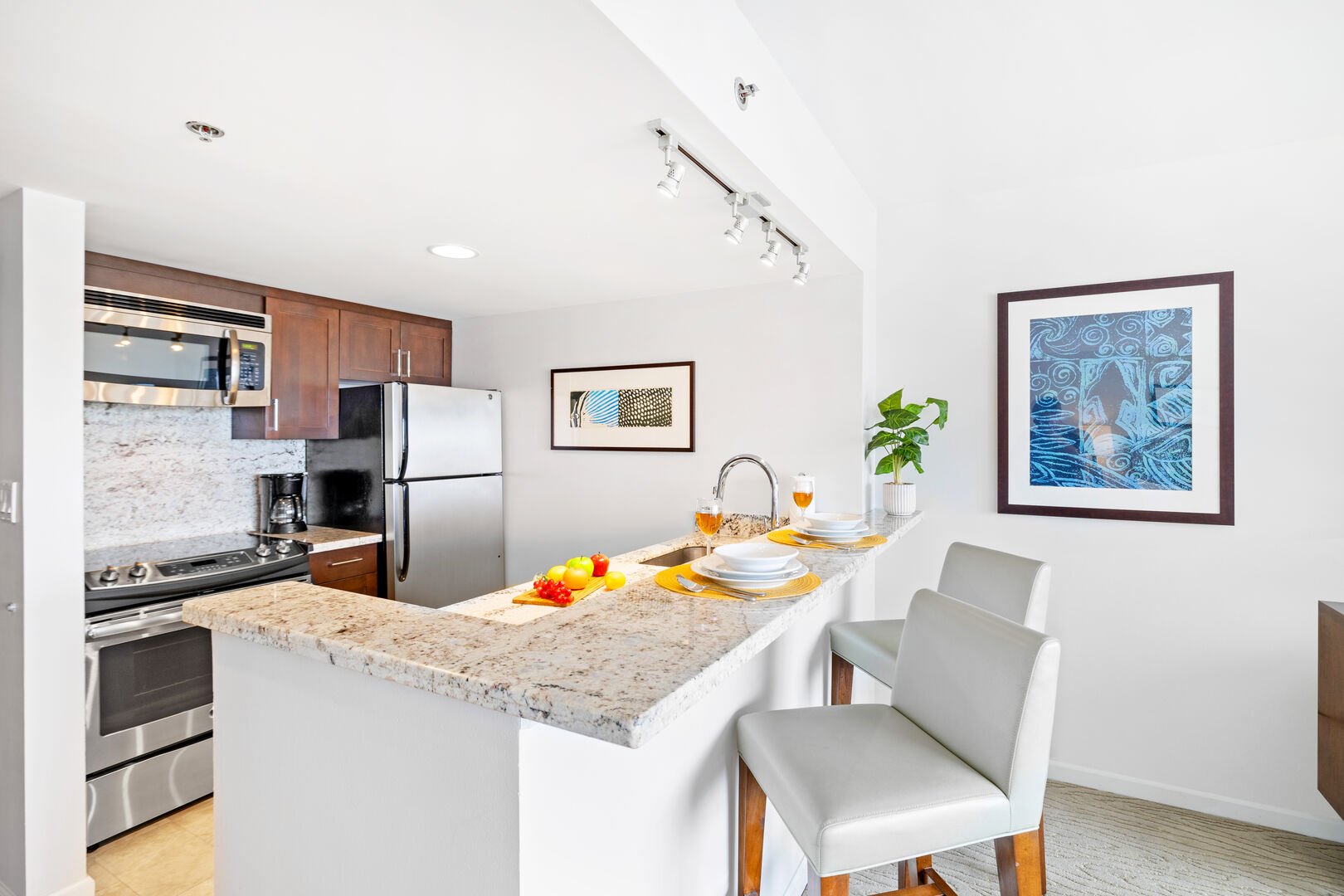 Fully equipped kitchen with elegant countertop and 2 bar stools.