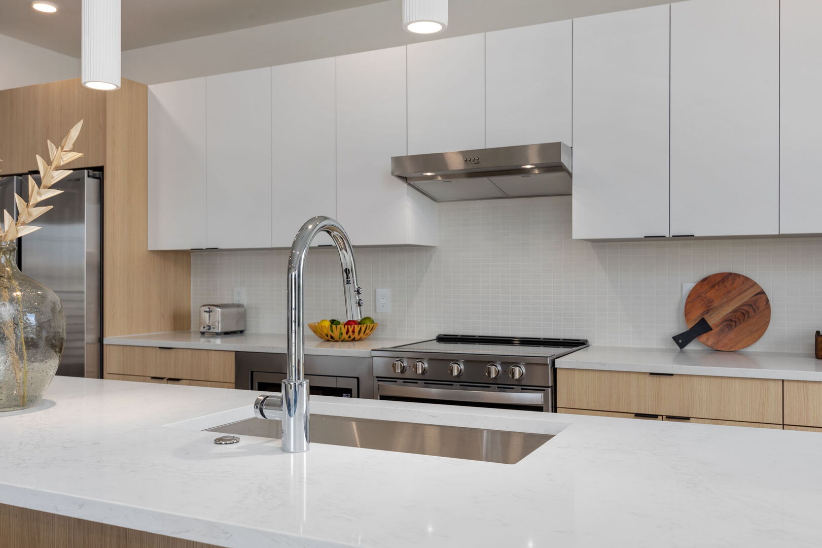 Fully equipped modern kitchen stocked with all culinary essentials and featuring stainless steel appliances with island bar seating.