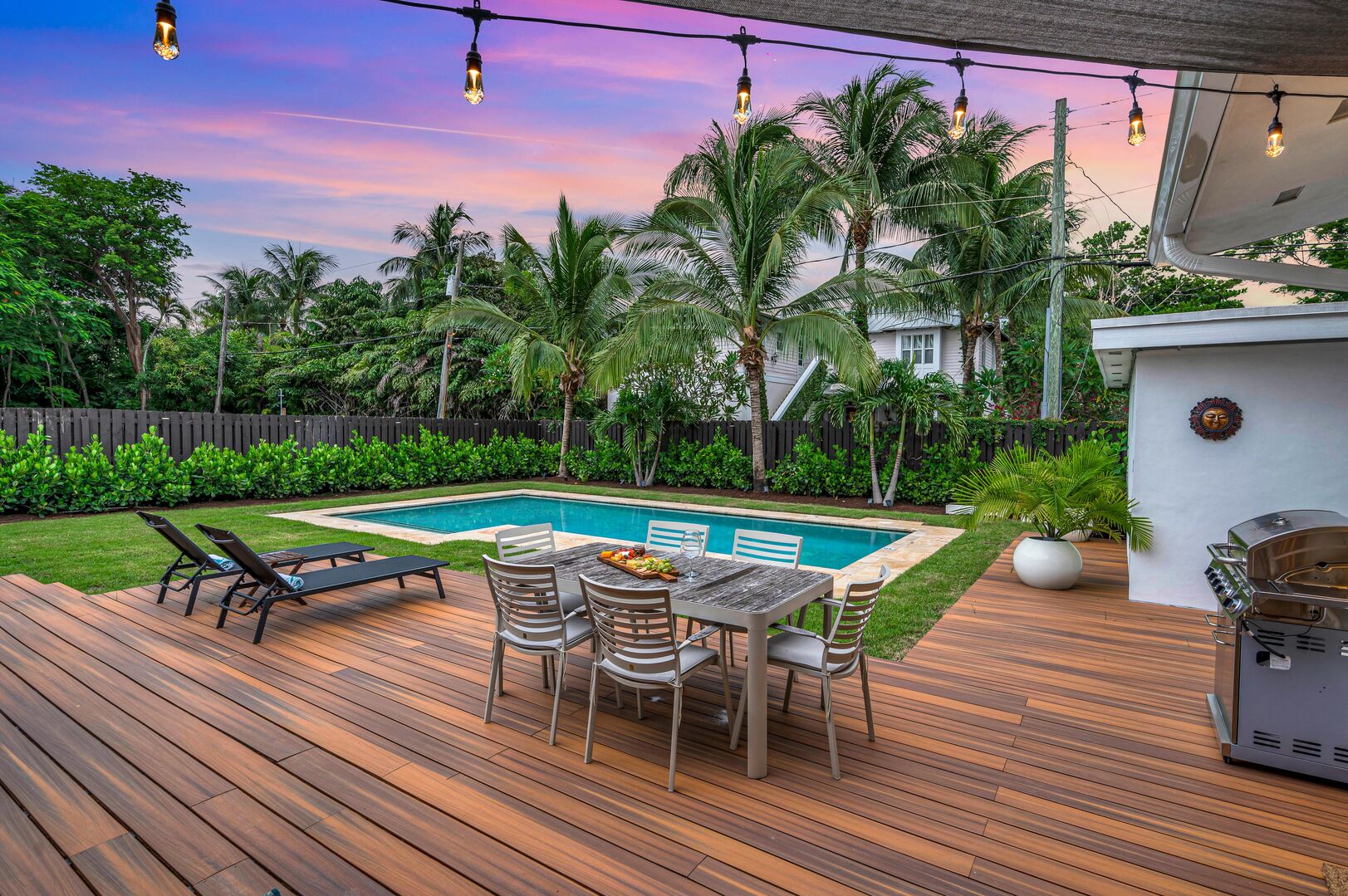 Florida Dreamscape: Immerse Yourself in Outdoor Splendor with Dining for Six, a Grilling Haven, and Lounge Area, All Beneath the Enchanting Pink Skies. Your Sunset Paradise Awaits.