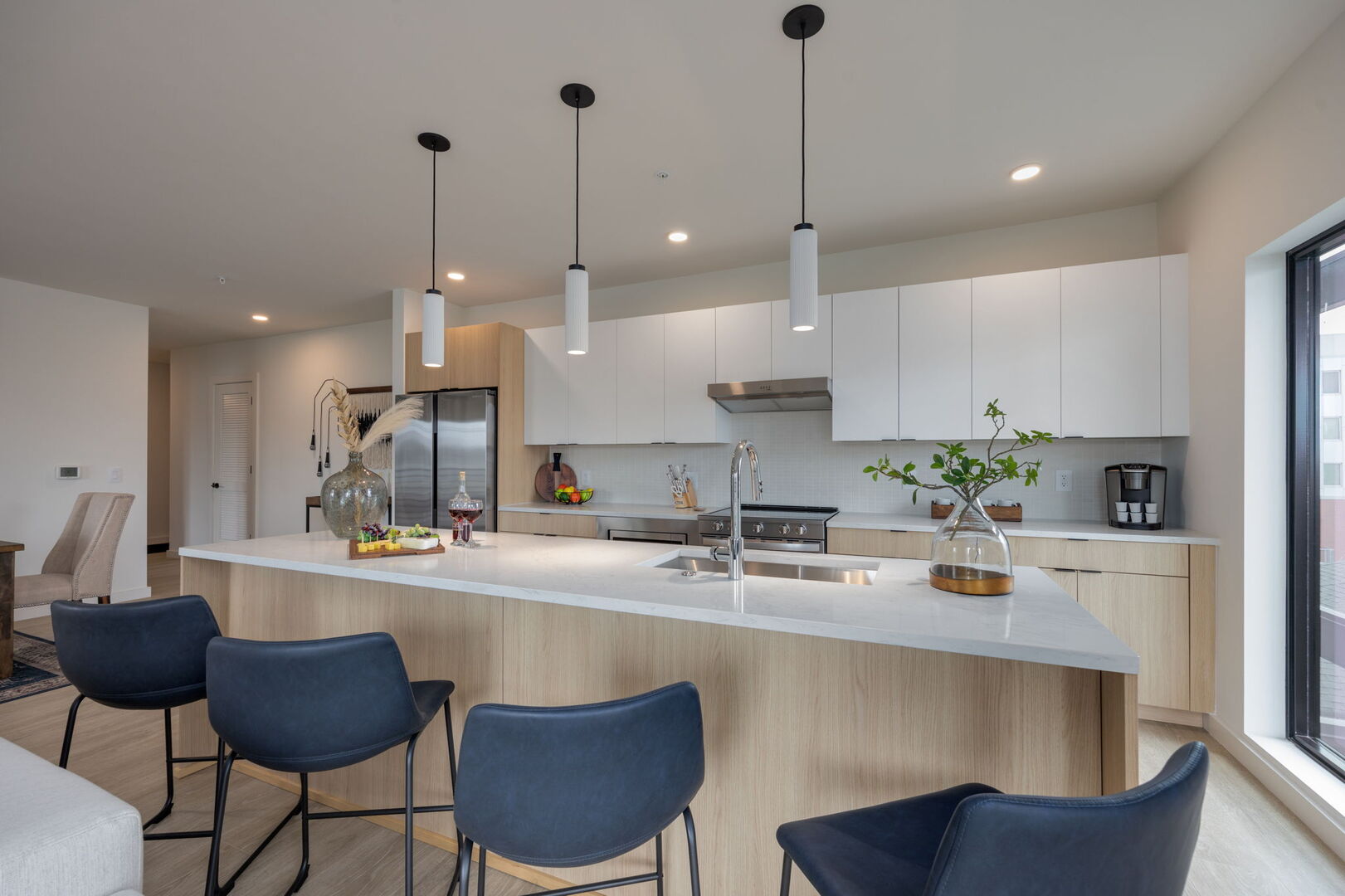 Fully equipped modern kitchen stocked with all culinary essentials and featuring stainless steel appliances with island bar seating.