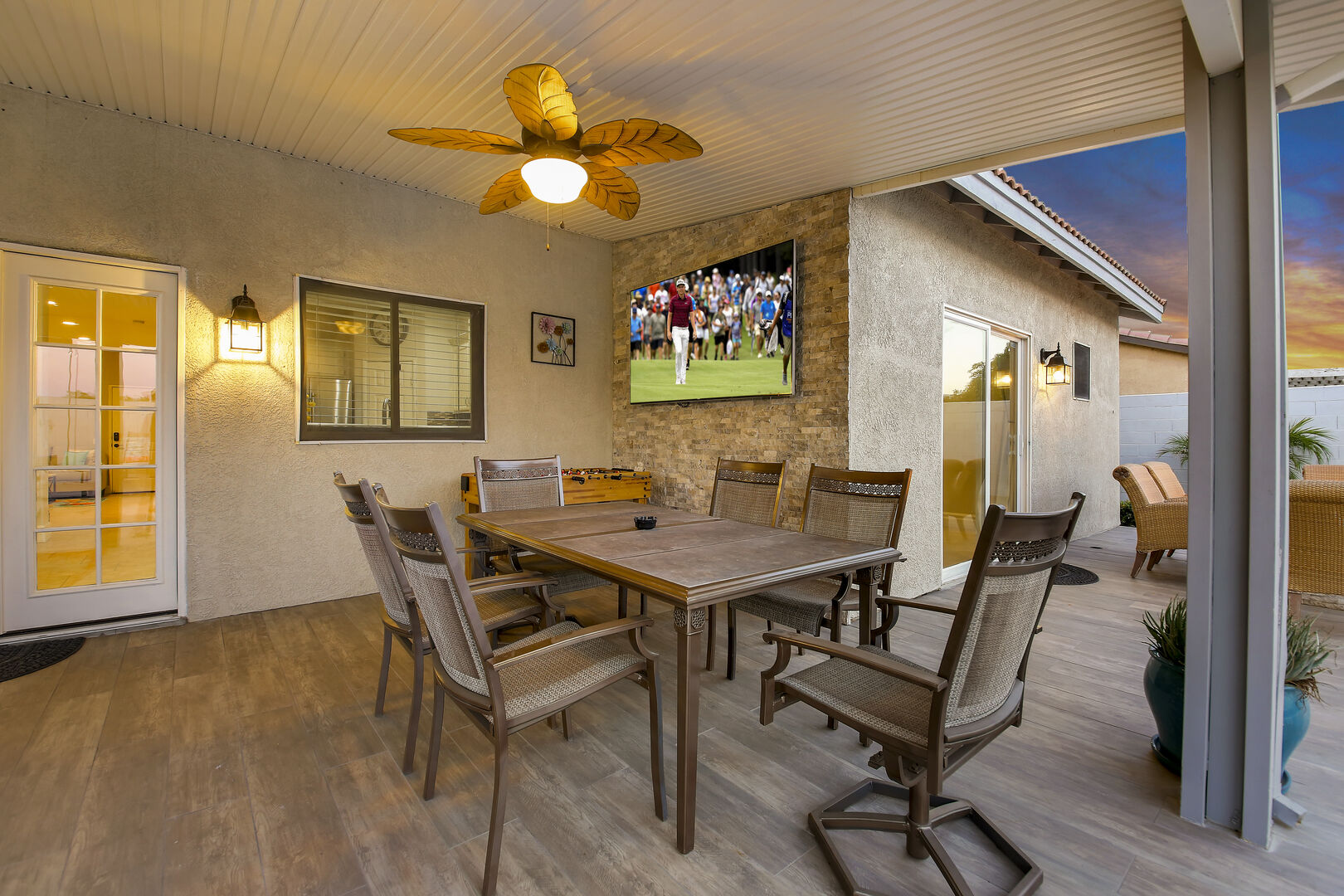 Dine alfresco at the outdoor table for six and stay cool under the ceiling fan as you watch your favorite games on the impressive 75-inch Samsung TV.