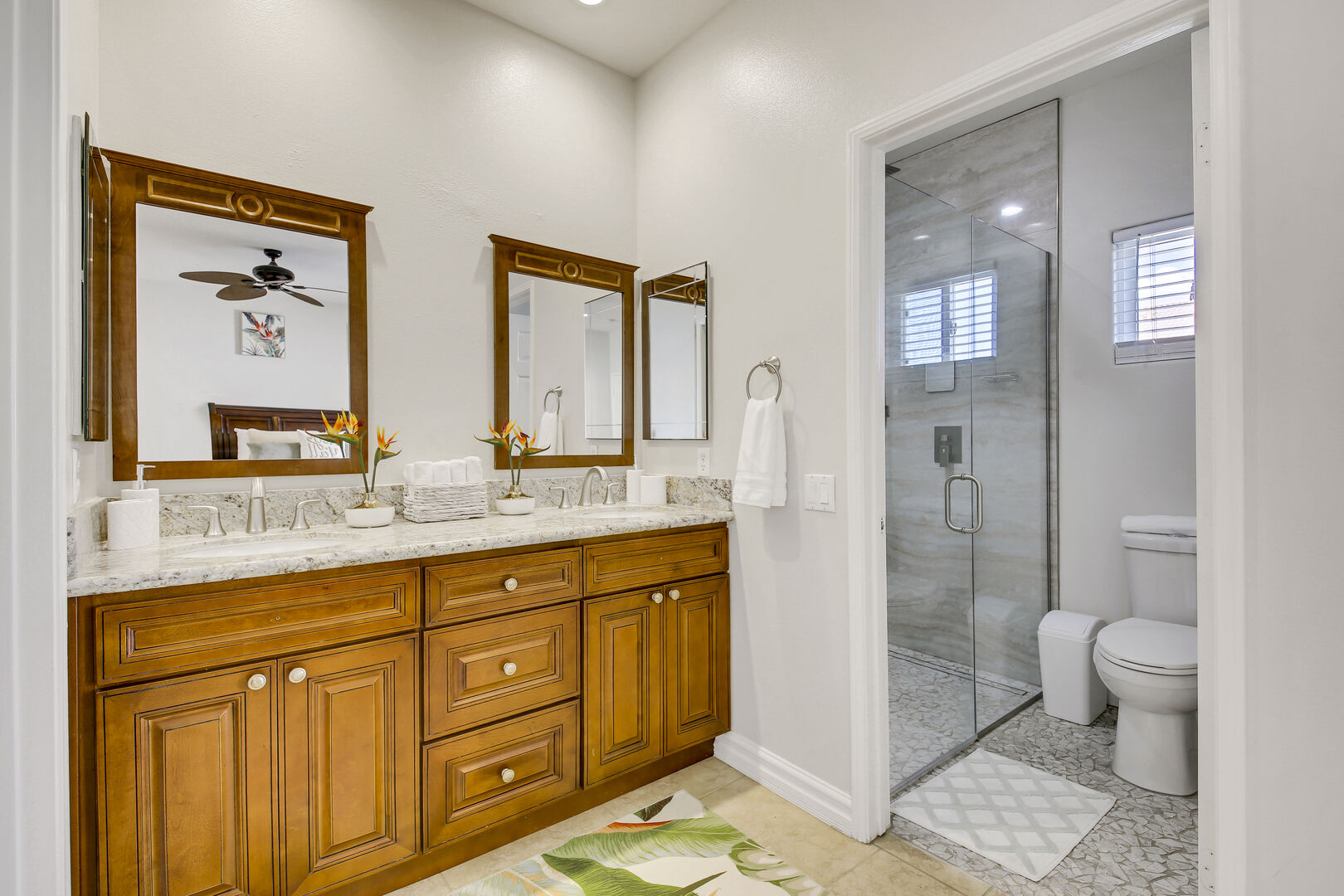 The private, en suite bathroom features a tile shower and double vanity sinks.