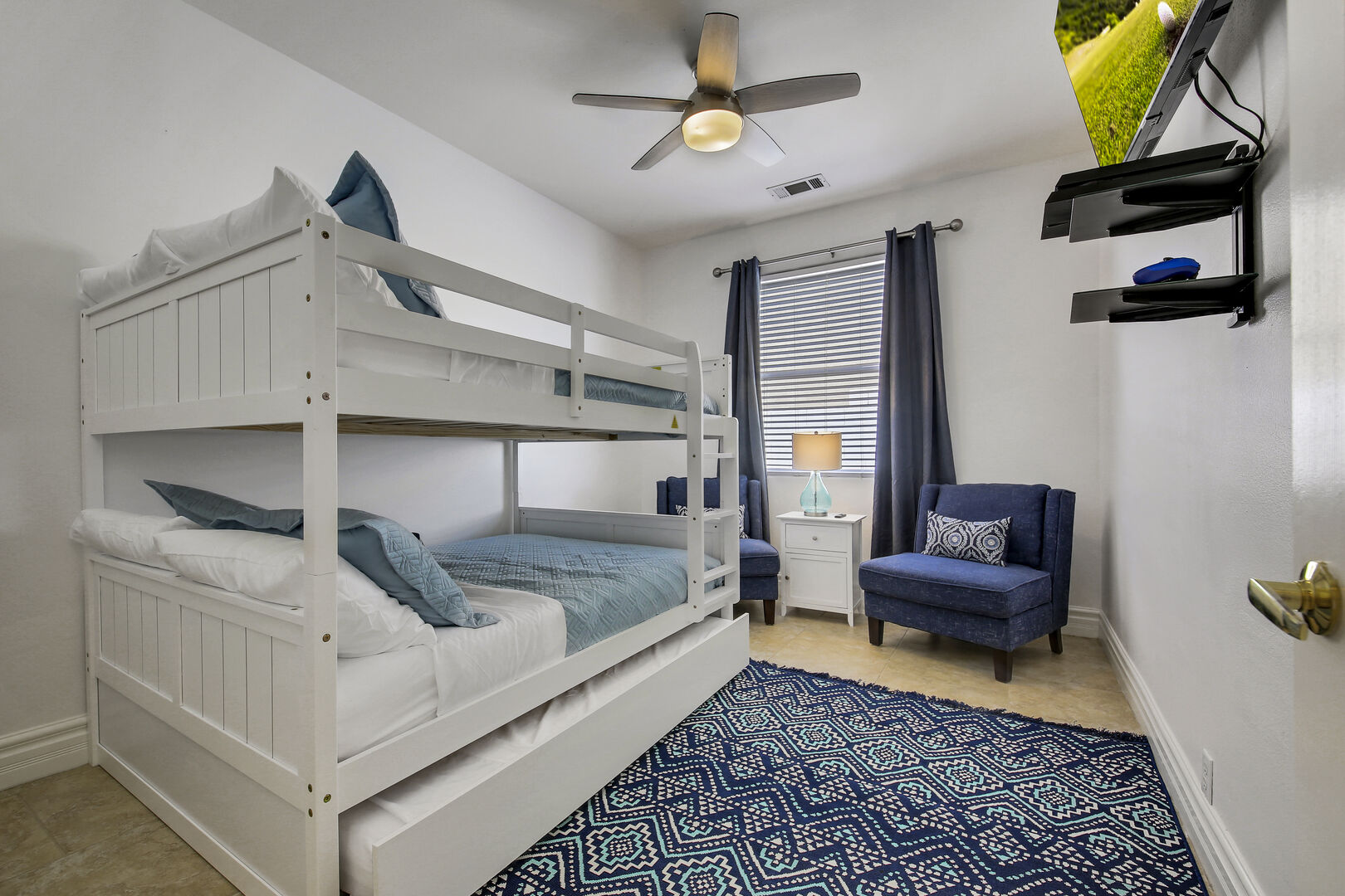 Bedroom 2 is located next to Master Suite 1 and features a Full Over Full with Twin Trundle Bunk Bed, 43-inch Samsung 4K Smart television, remote-controlled ceiling fan, and reach-in closet.